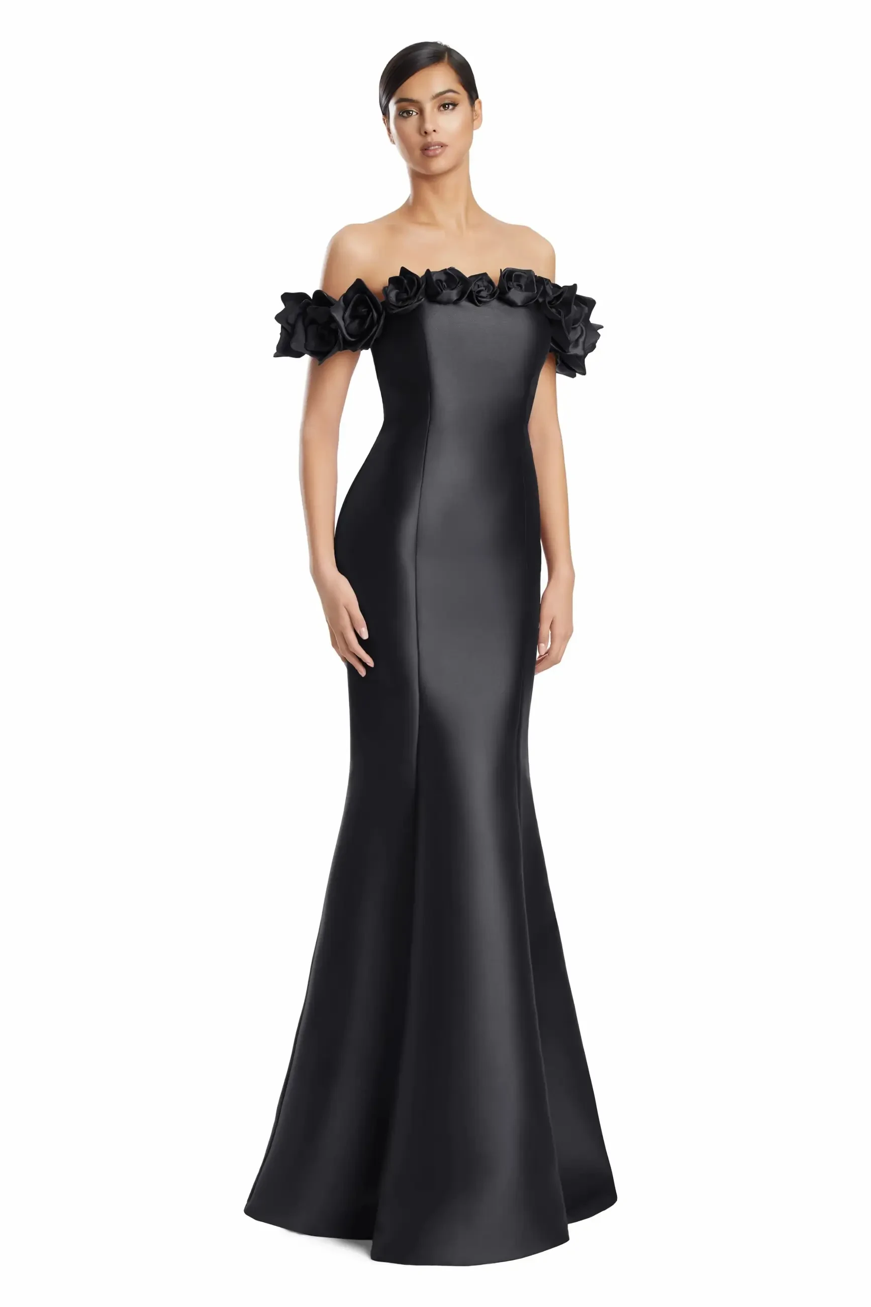 A woman wearing a black, off-the-shoulder evening gown with floral embellishments around the neckline.
