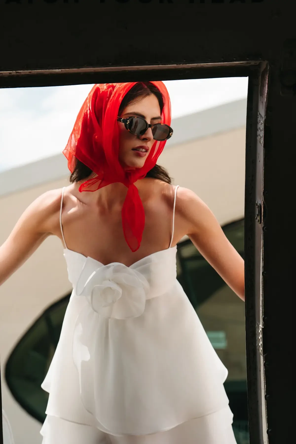 model is wearing a bridal mini dress with a red head scarf