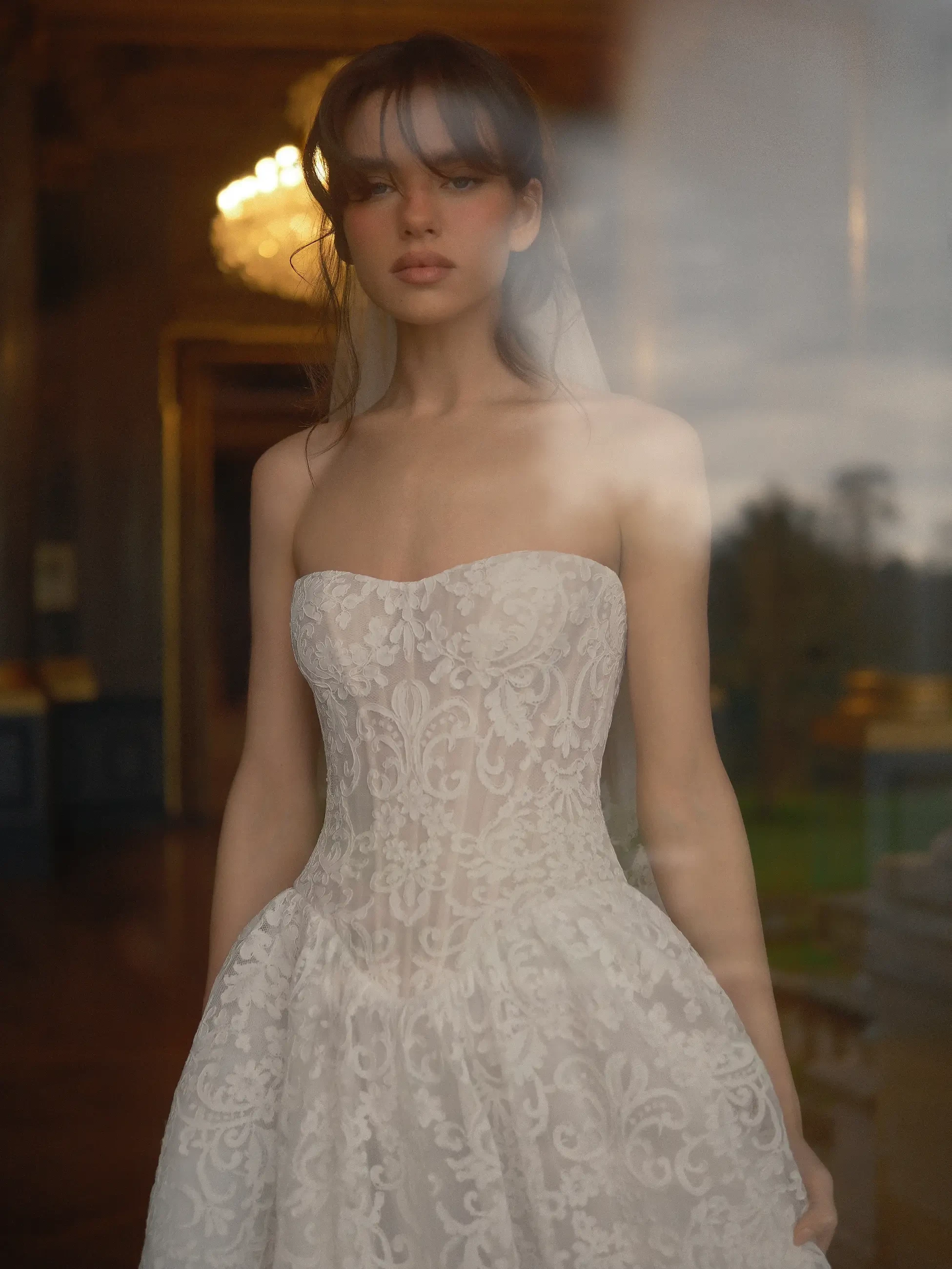 model is wearing a strapless lace bridal gown