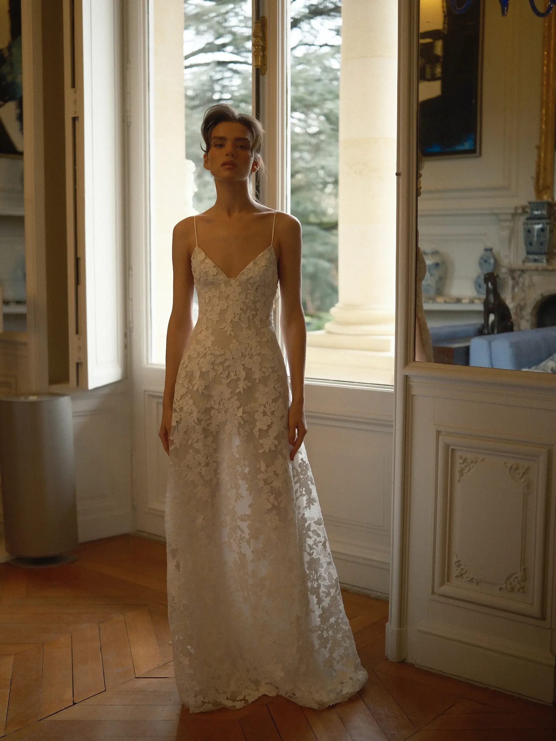 model is wearing a sleeveless lace bridal gown
