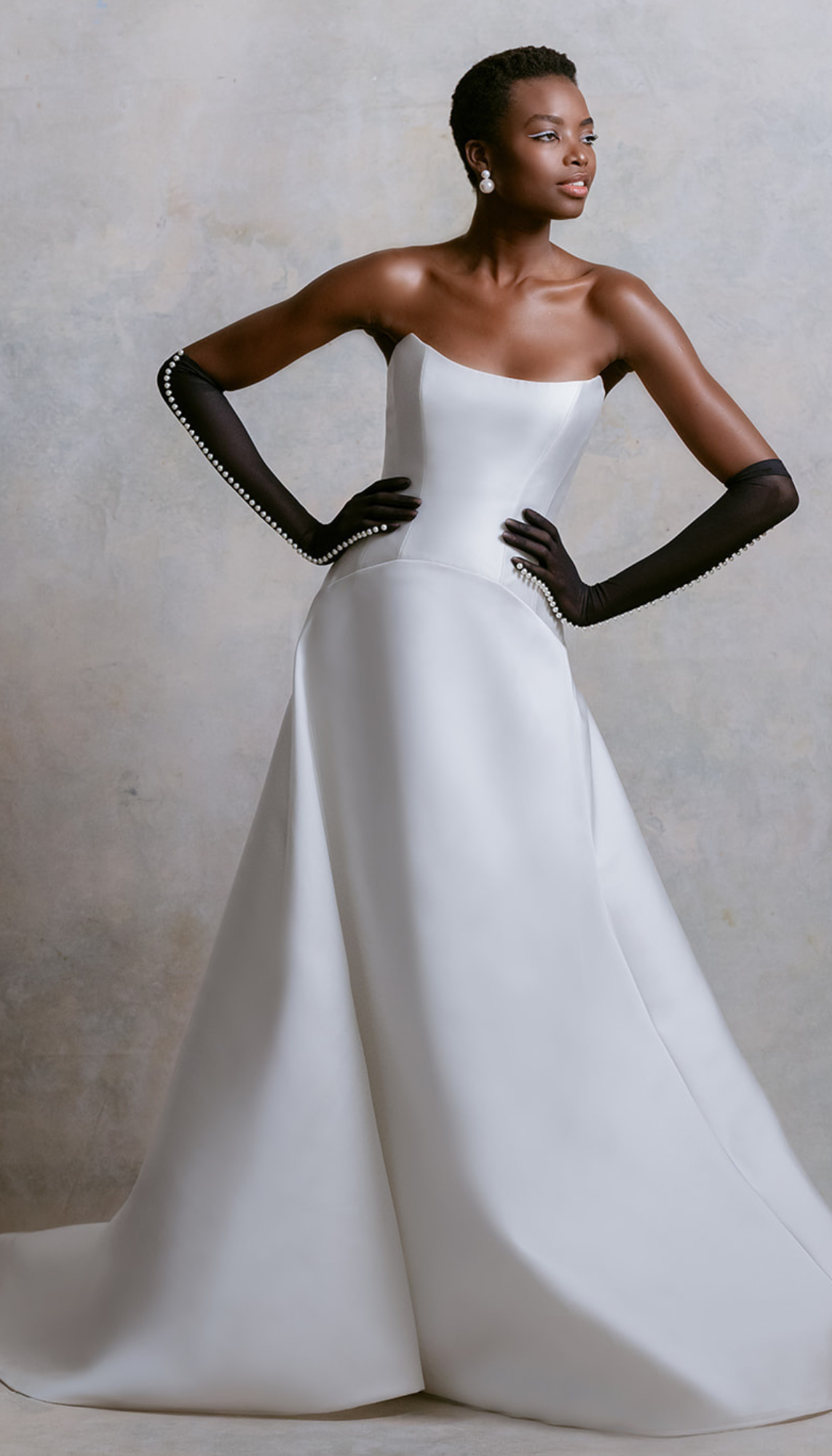 model is wearing a sleek strapless a-line bridal gown from mark ingram