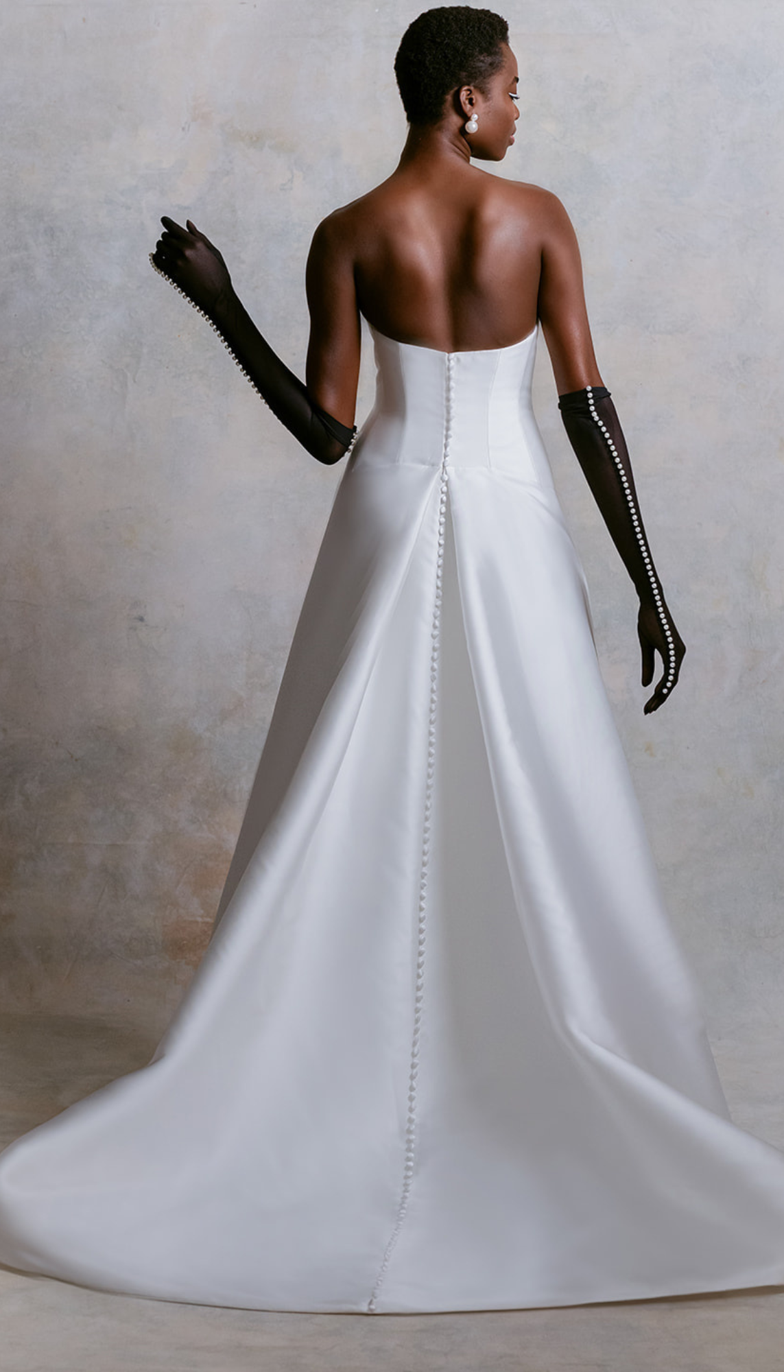 model is wearing a sleek strapless a-line bridal gown from mark ingram
