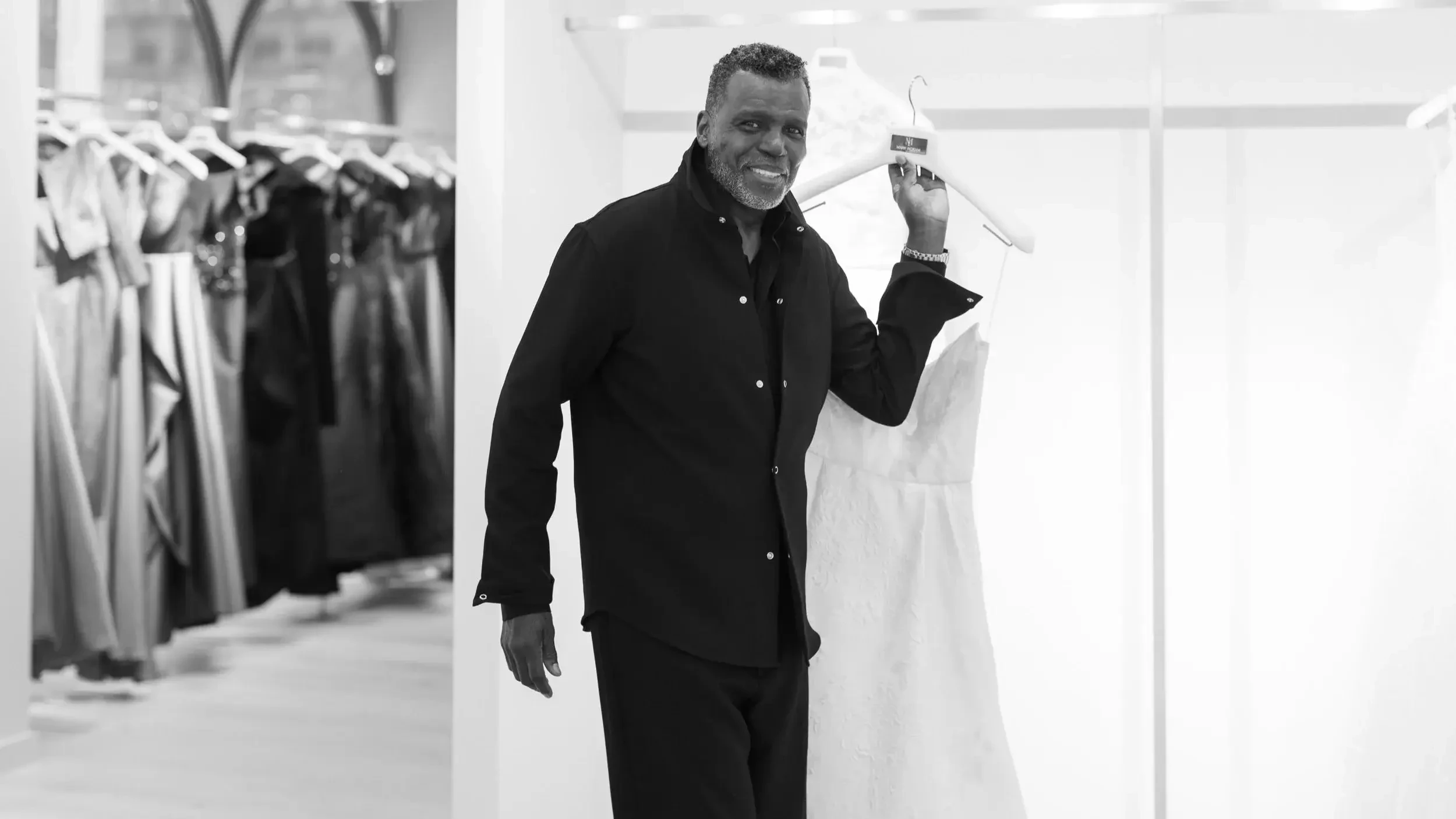 image shows mark ingram holding one of his wedding dresses