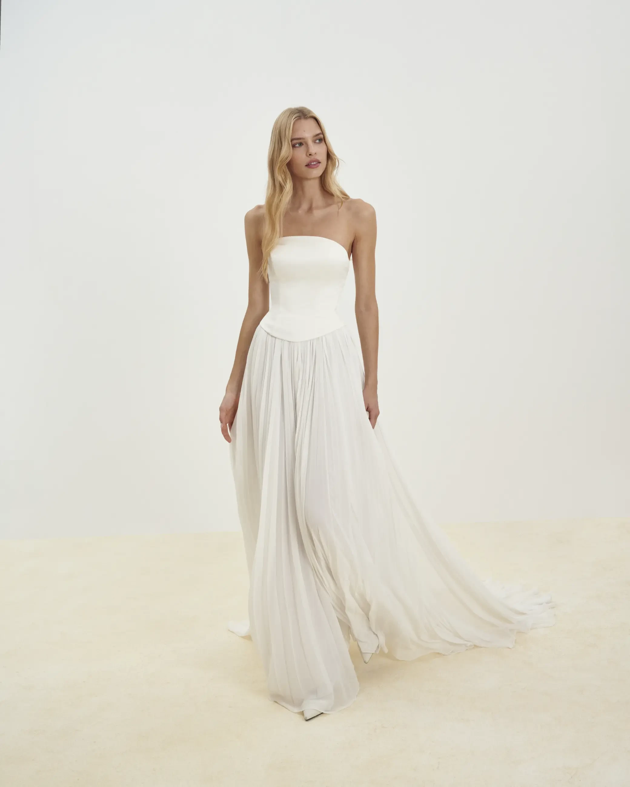 model is wearing a breezy strapless a-line wedding gown