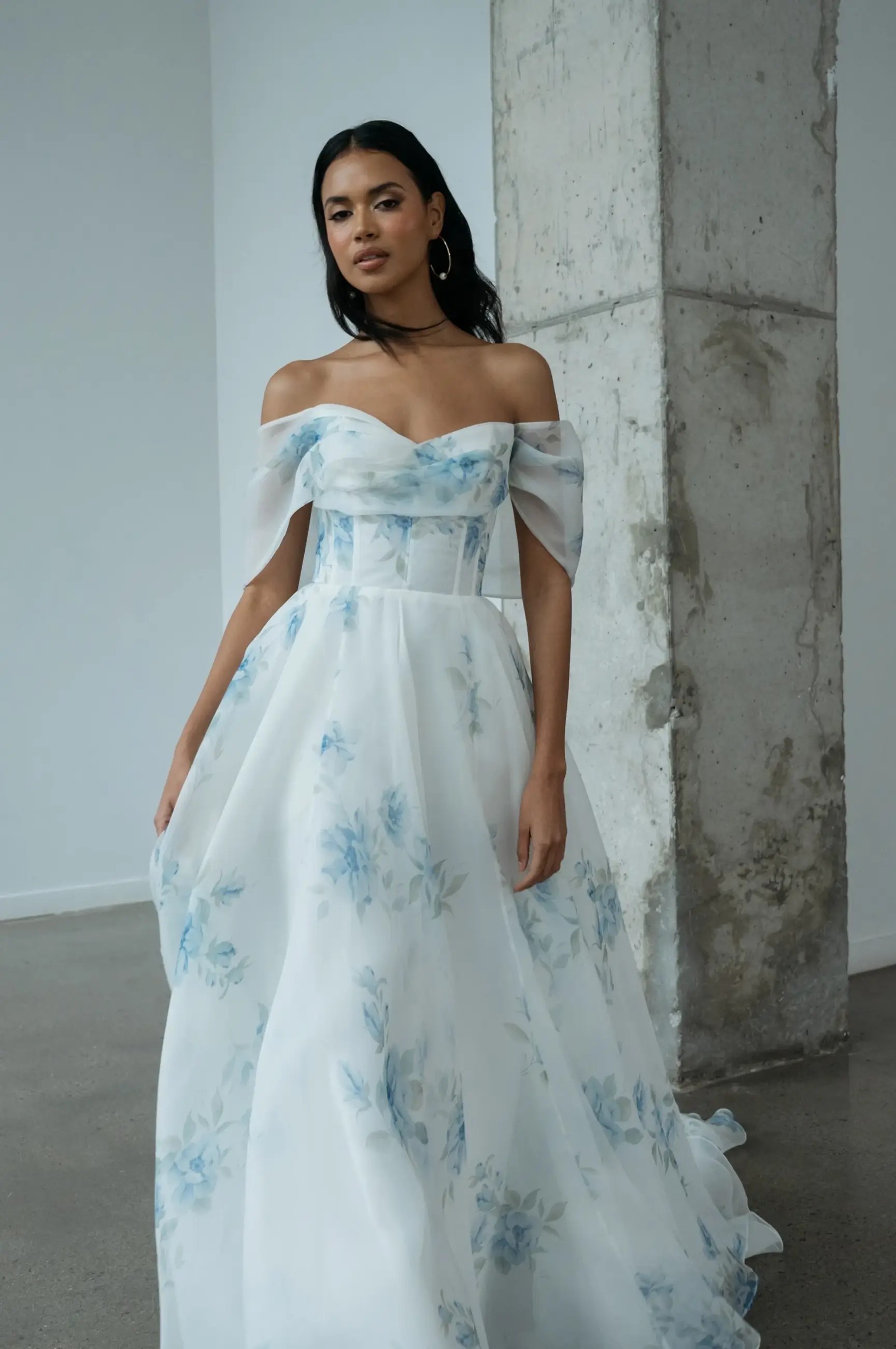 Model is wearing an organza wedding dress with a draped sweetheart neckline