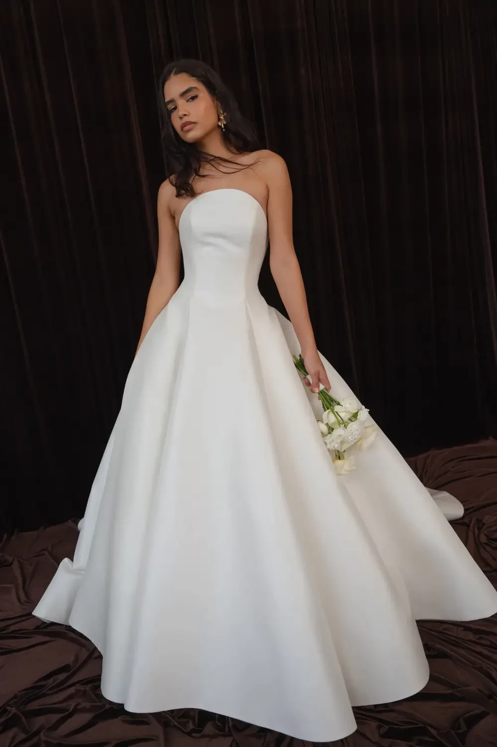model is wearing a strapless a-line bridal gown