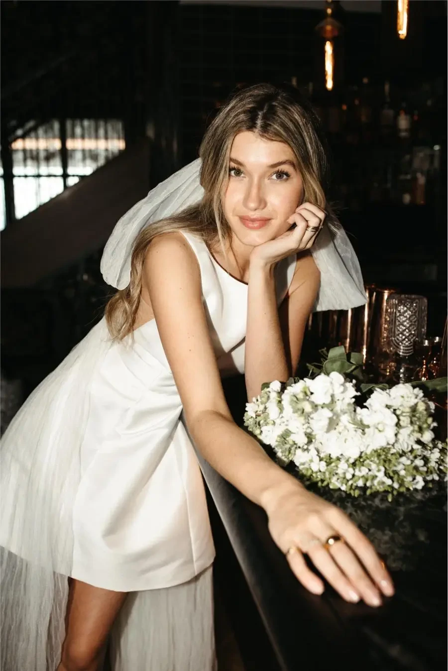 model is wearing a bridal mini dress from by watters