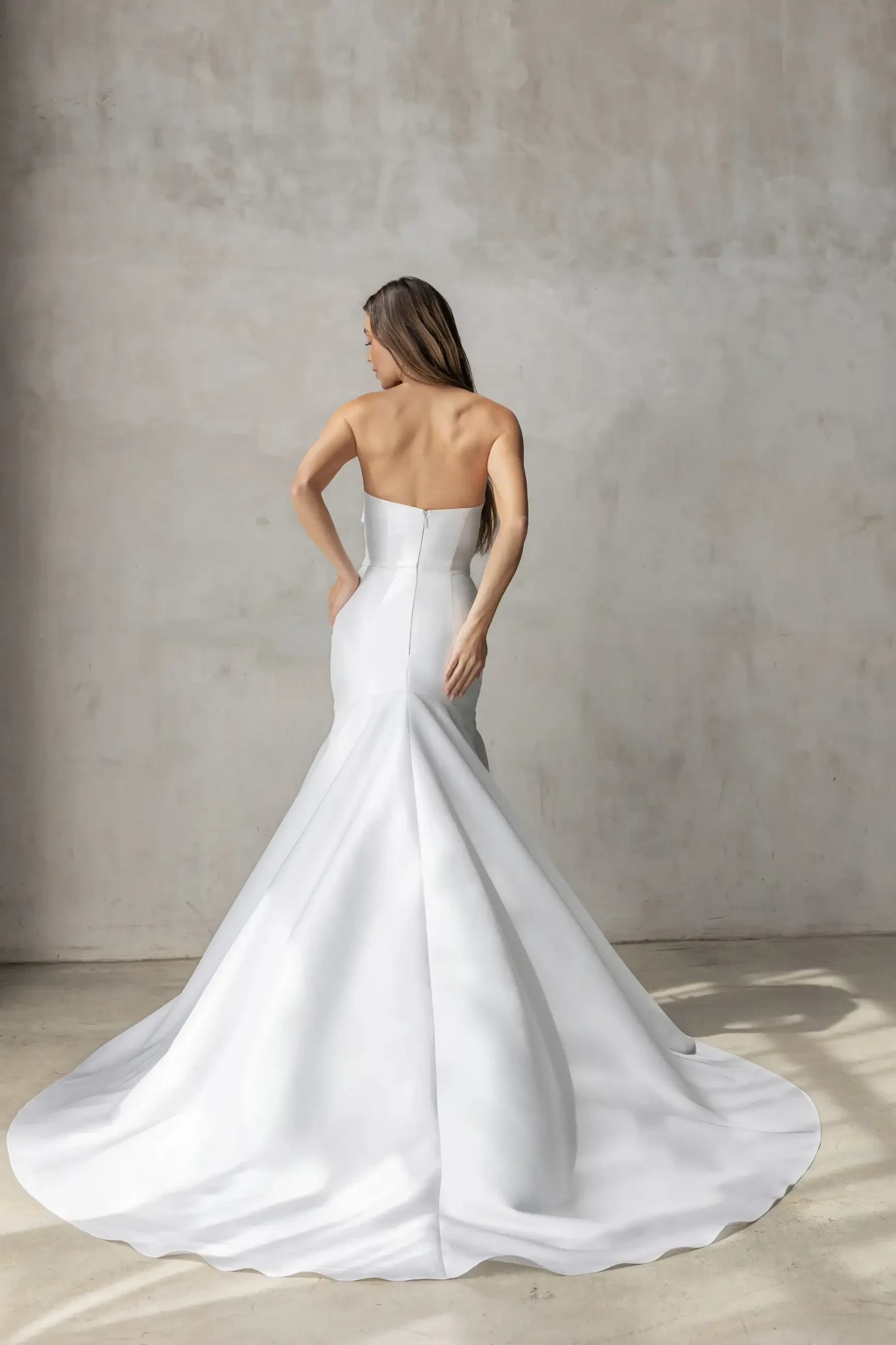 Model wears a strapless fit and flare gown in Spanish Mikado with a sleek mermaid silhouette.