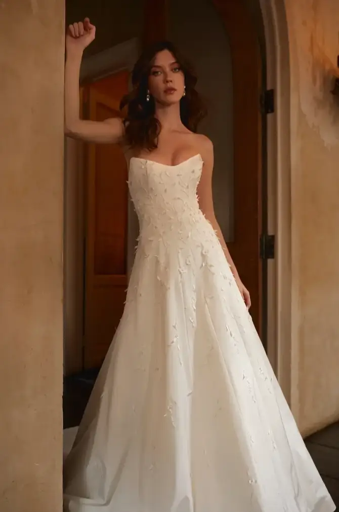 Model is wearing a strapless a-line wedding dress with texture and a sweetheart neckline